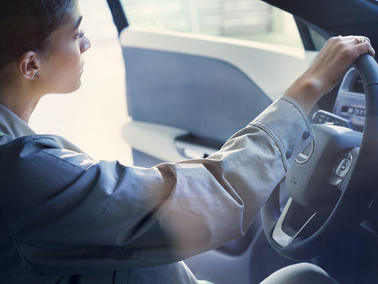 A woman sat in a Lexus RZ with the driver door open