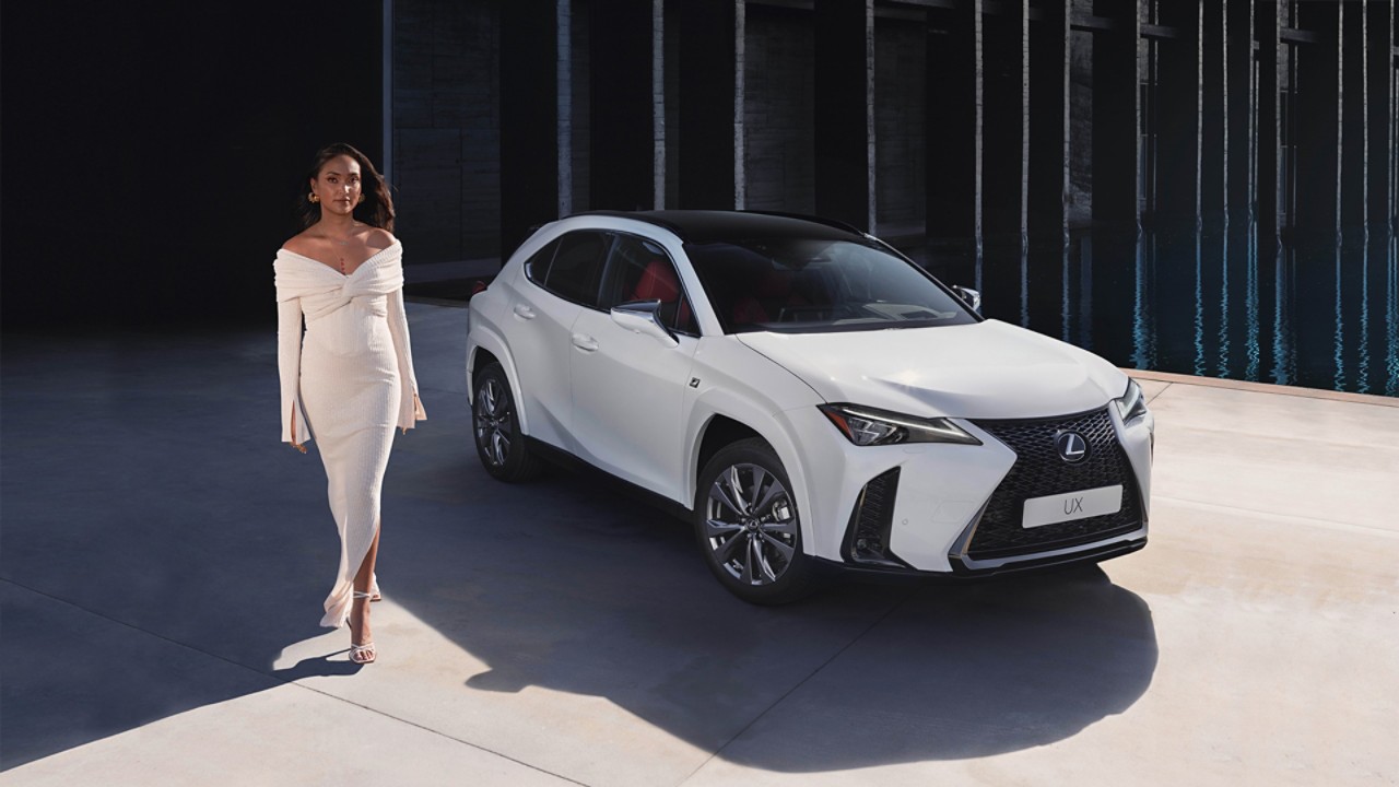 Joy Crookes leaning on the bonnet of a Lexus UX