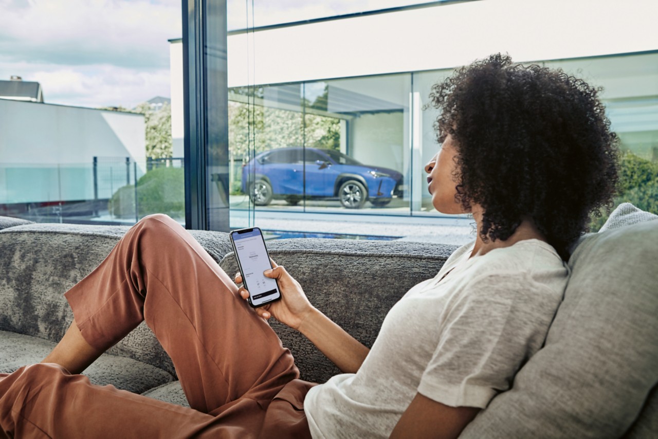 A person sat at home with a Lexus on the driveway