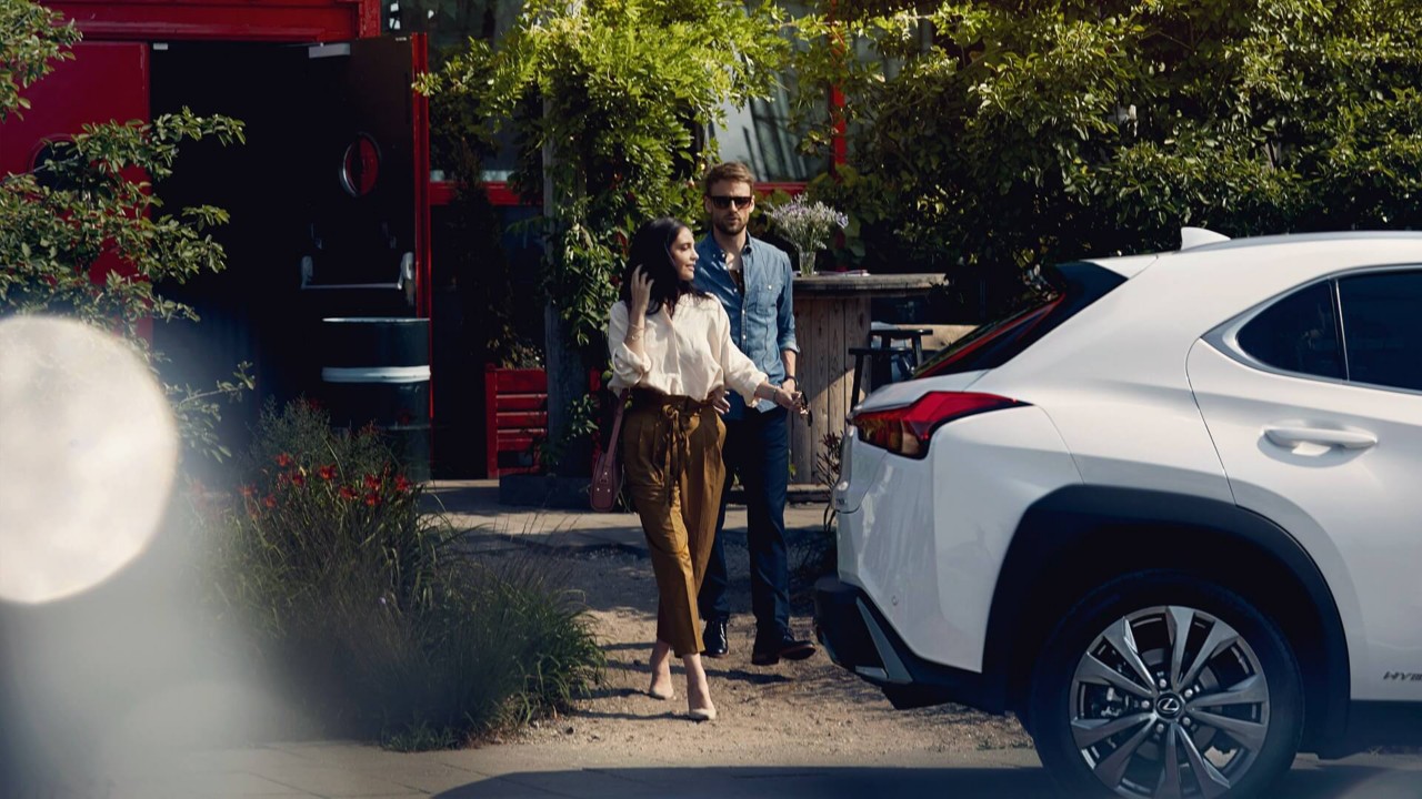 Couple standing by a Lexus.
