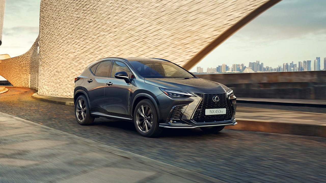 Lexus NX 450h+ driving in a city location 