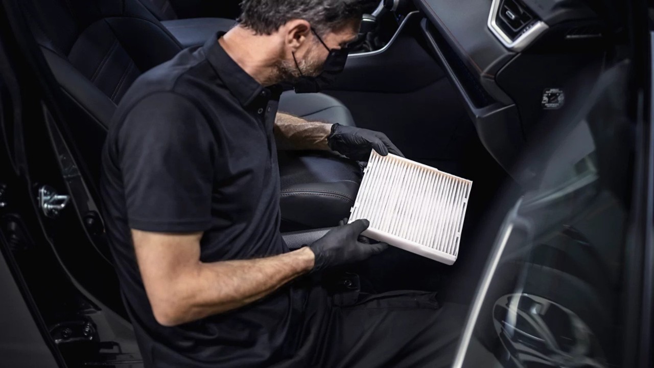 A Lexus mechanic working on a Lexus undercarriage